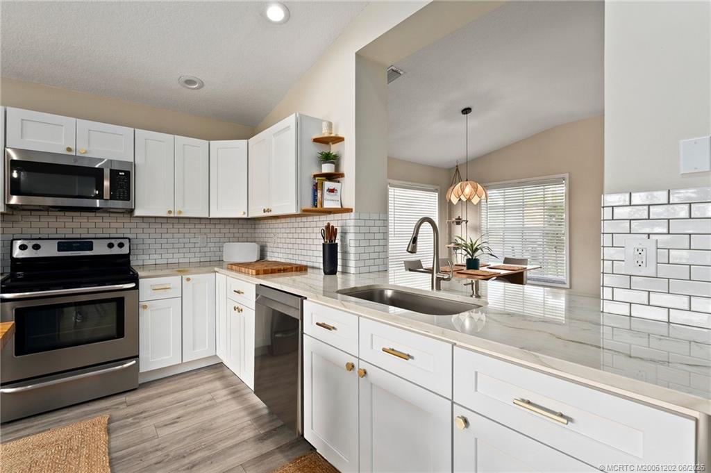 6351 Adams Street Jupiter, FL 33458 - Photo 9 of 42 a kitchen with sink a stove and cabinets