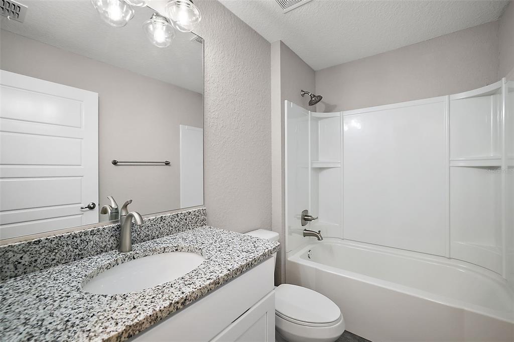 84 Pecan Run Ocala, FL 34472 - Photo 23 of 24 a bathroom with a granite countertop sink a toilet and shower