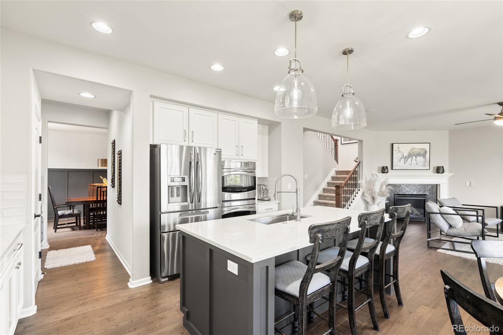 10415 Startrail Court Highlands Ranch, CO 80126 - Photo 12 of 49 a kitchen with stainless steel appliances kitchen island granite countertop a refrigerator and a stove top oven