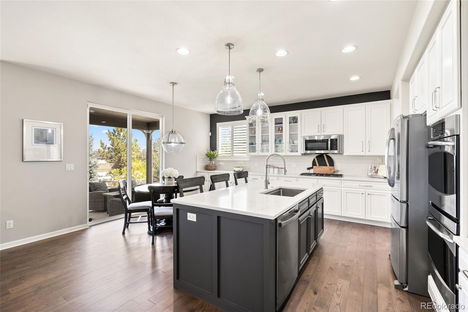 10415 Startrail Court Highlands Ranch, CO 80126 - Photo 16 of 49 a large white kitchen with lots of counter space a sink appliances and a large window