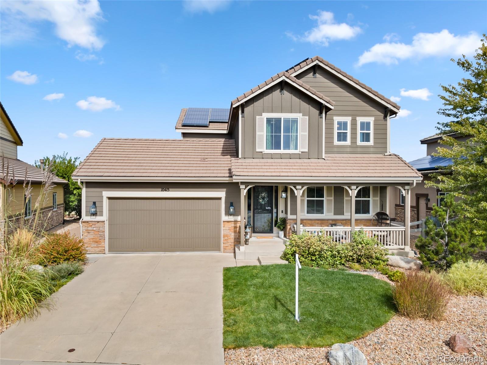 10415 Startrail Court Highlands Ranch, CO 80126 - Photo 3 of 49 a front view of a house with a yard and garage