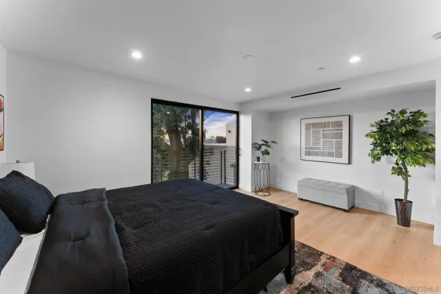 a bedroom with a large bed and a potted plant