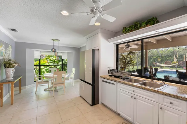 a kitchen with granite countertop a sink and a refrigerator