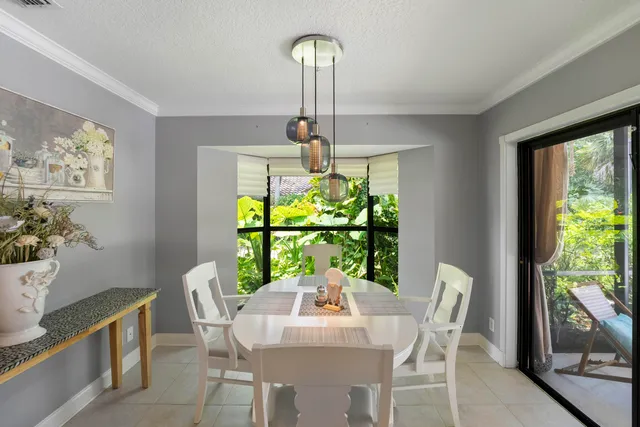 a dining room with furniture a potted plant and a chandelier
