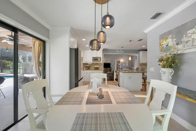 a view of a dining room with furniture a chandelier and wooden floor