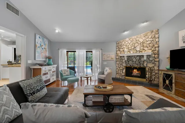 a living room with furniture a flat screen tv and a fireplace