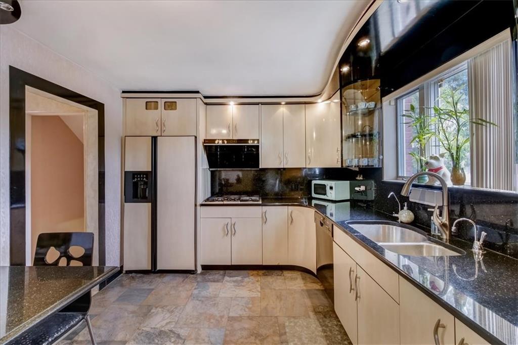 829 Bruce Drive East Meadow, NY 11554 - Photo 7 of 27 a kitchen with stainless steel appliances granite countertop a refrigerator a sink and a stove