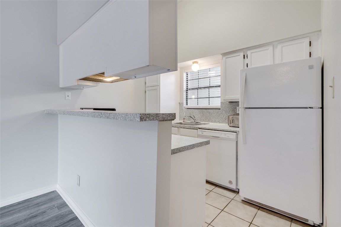 1908 San Antonio Street, Unit 306 Austin, TX 78705 - Photo 11 of 28 a white refrigerator freezer and a wooden floor