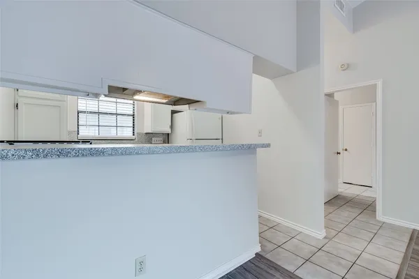 a kitchen with granite countertop white cabinets and white appliances