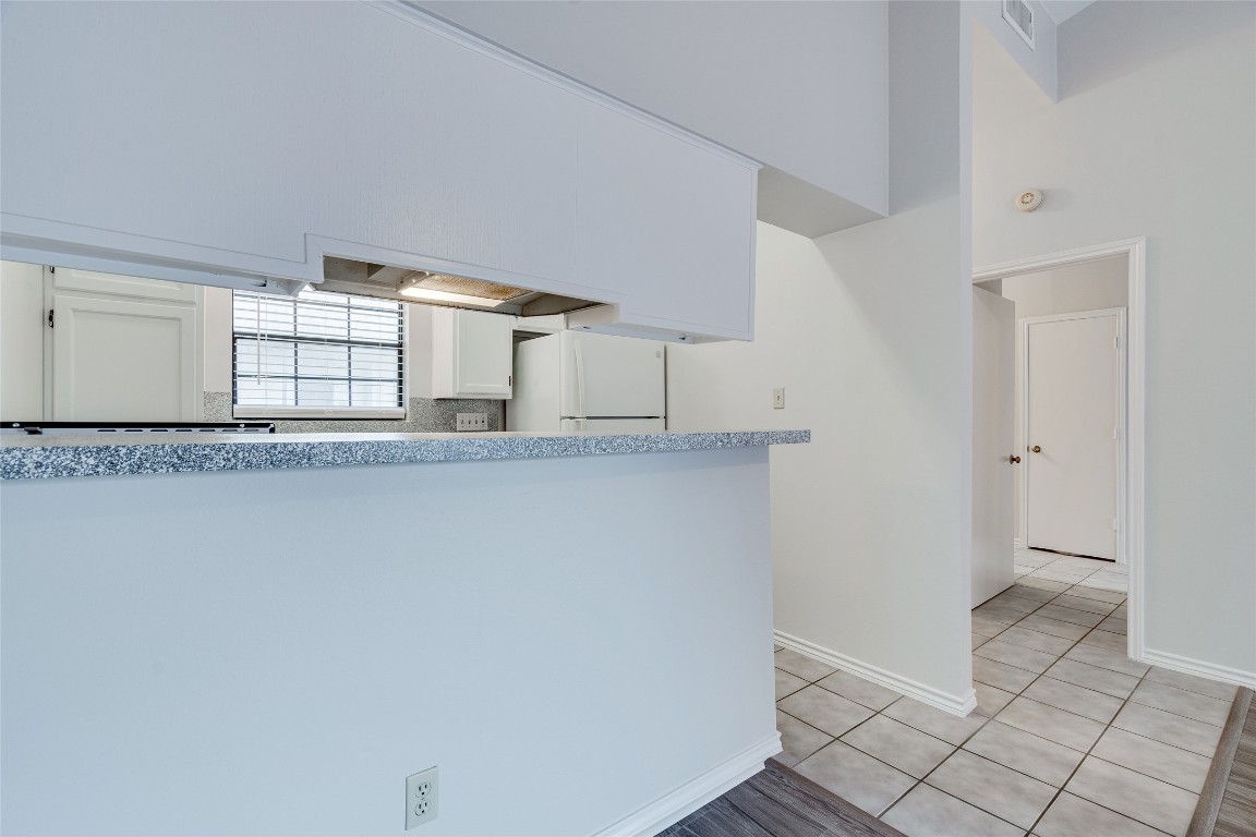 1908 San Antonio Street, Unit 306 Austin, TX 78705 - Photo 12 of 28 a view of a kitchen with white cabinets and wooden floor