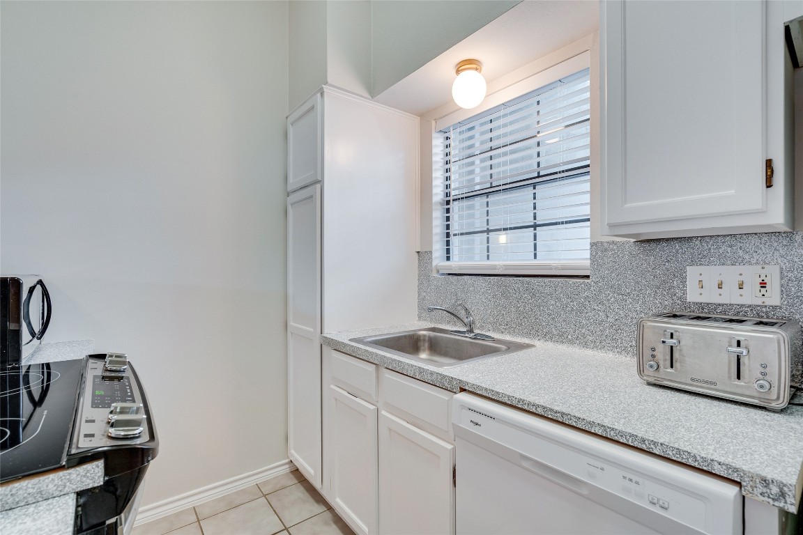 1908 San Antonio Street, Unit 306 Austin, TX 78705 - Photo 13 of 28 a kitchen with granite countertop white cabinets and white appliances
