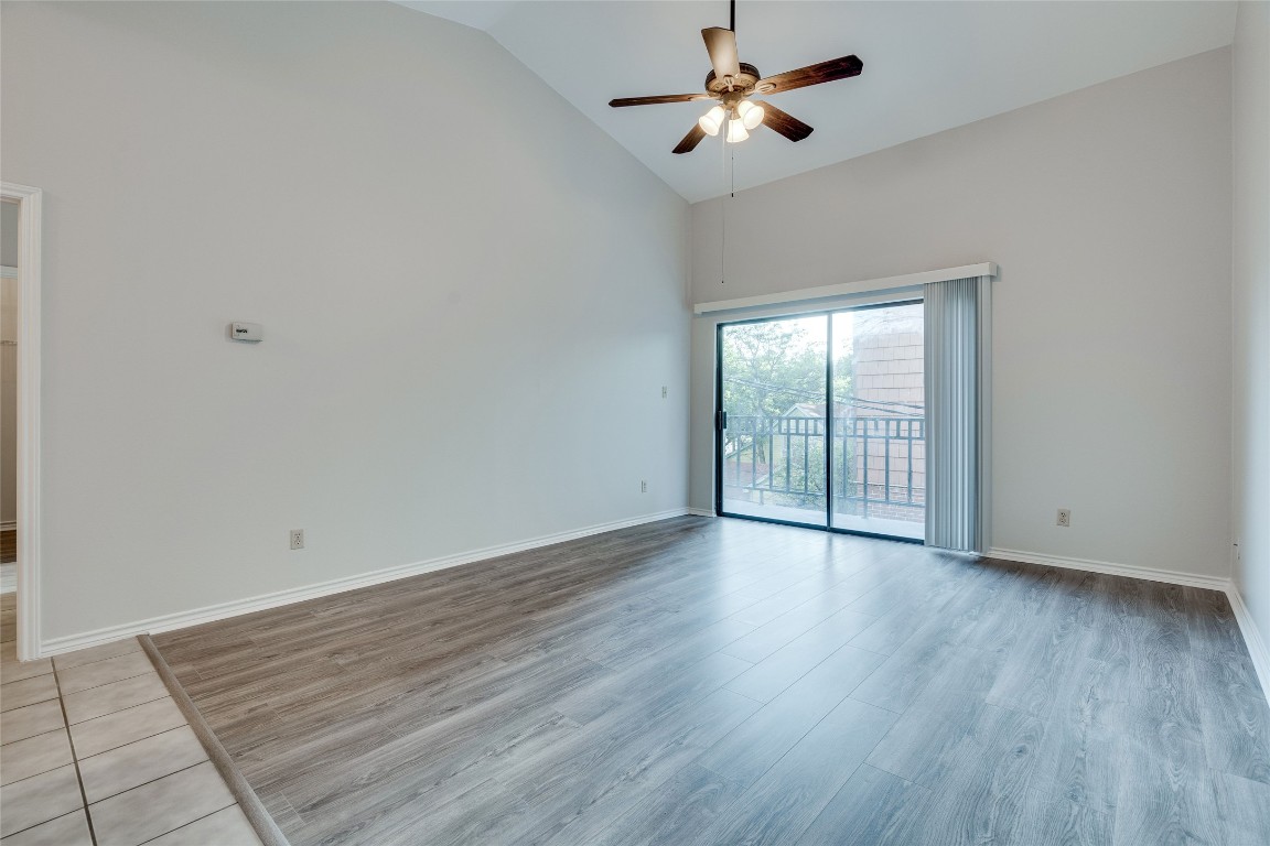 1908 San Antonio Street, Unit 306 Austin, TX 78705 - Photo 8 of 28 an empty room with wooden floor fan and windows