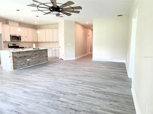 a kitchen with a sink and wooden floor