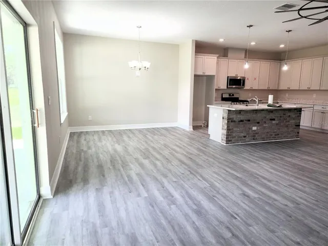 a large kitchen with stainless steel appliances kitchen island wooden floors and granite counter tops