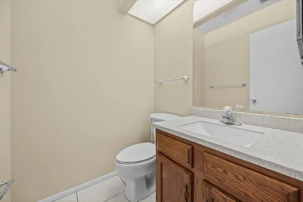 a bathroom with a granite countertop toilet sink and mirror