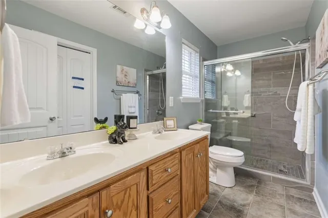 a bathroom with a double vanity sink toilet and shower