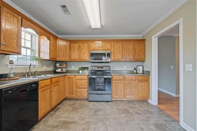 a kitchen with stainless steel appliances granite countertop a stove top oven a sink dishwasher and a microwave oven on the blue kitchen countertops