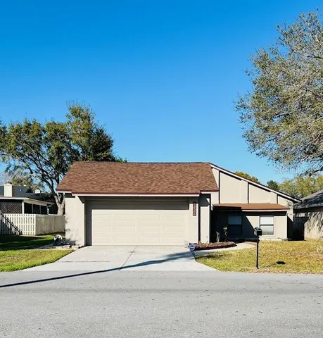 a view of a house with a street and large tree