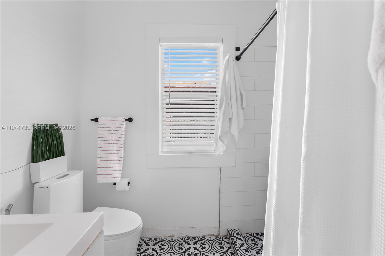 2811 Southwest 17th Street Miami, FL 33145 - Photo 20 of 36 a bathroom with a shower a toilet and a window