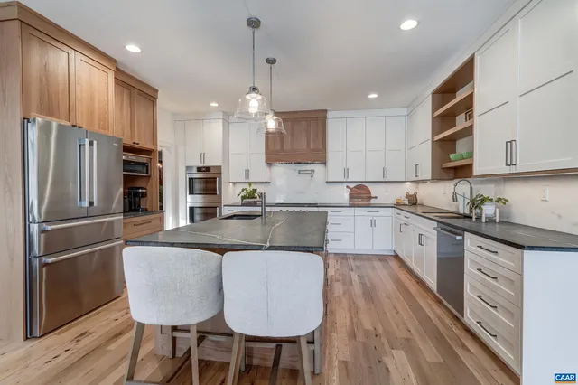 a kitchen with stainless steel appliances granite countertop white cabinets and a sink
