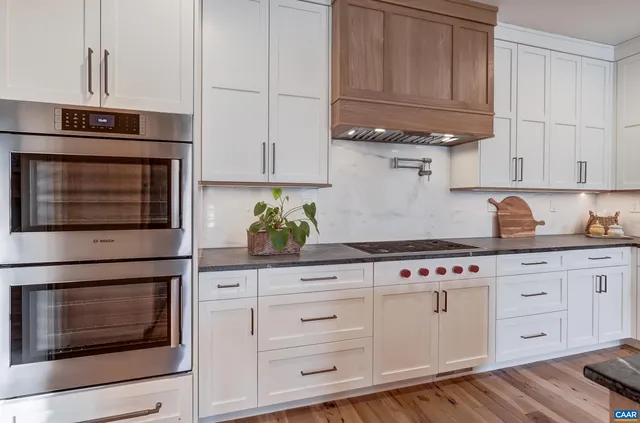 a kitchen with granite countertop white cabinets and stainless steel appliances