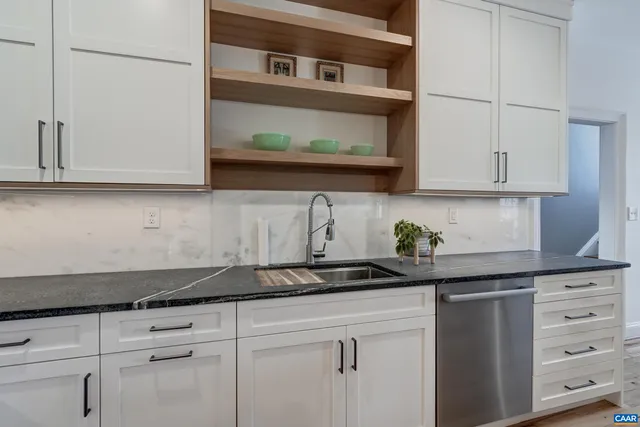 a spacious bedroom with a bed a fireplace and cabinets