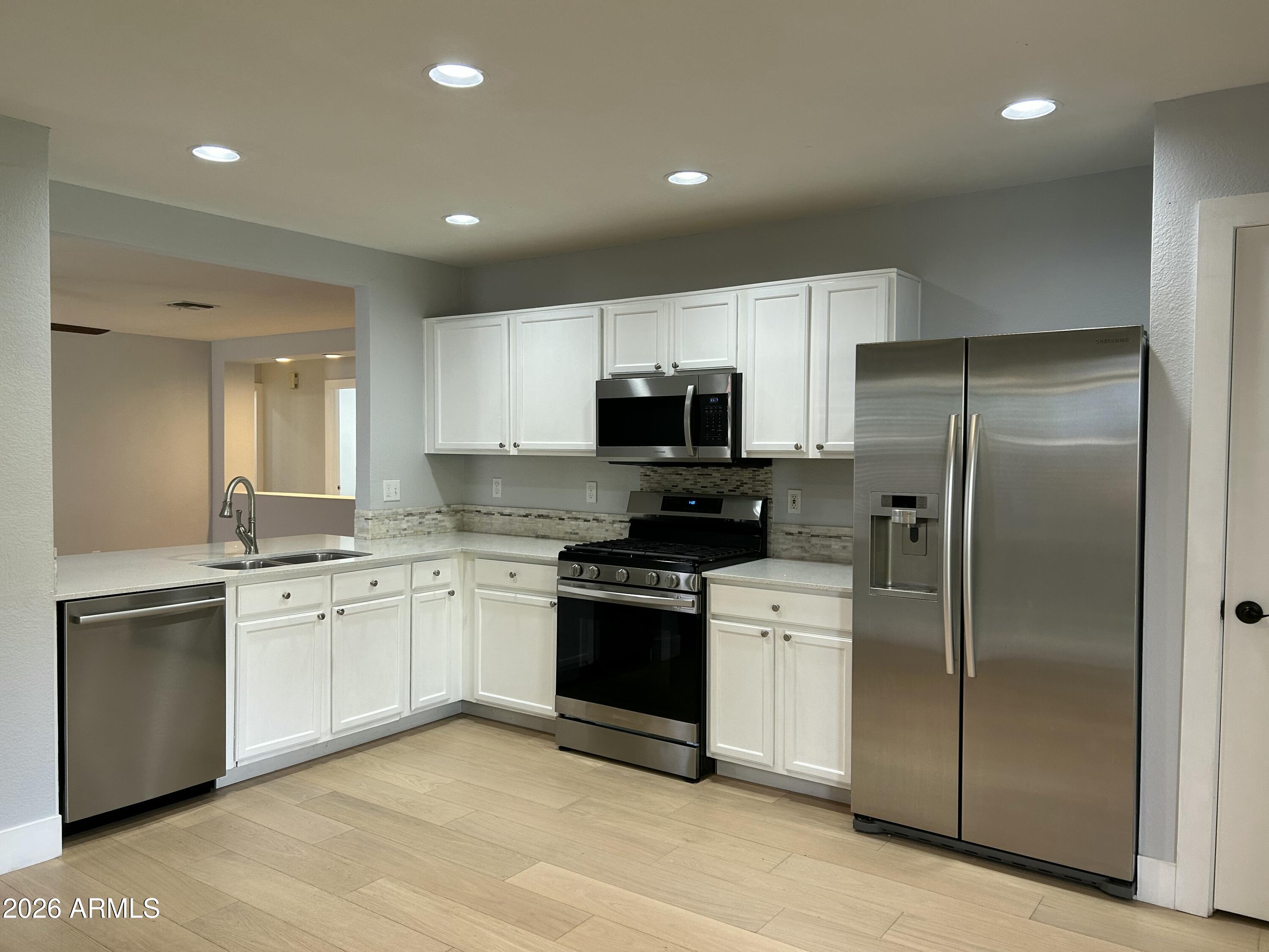 3216 West Mark Lane Phoenix, AZ 85083 - Photo 4 of 23 a kitchen with a sink stainless steel appliances and cabinets
