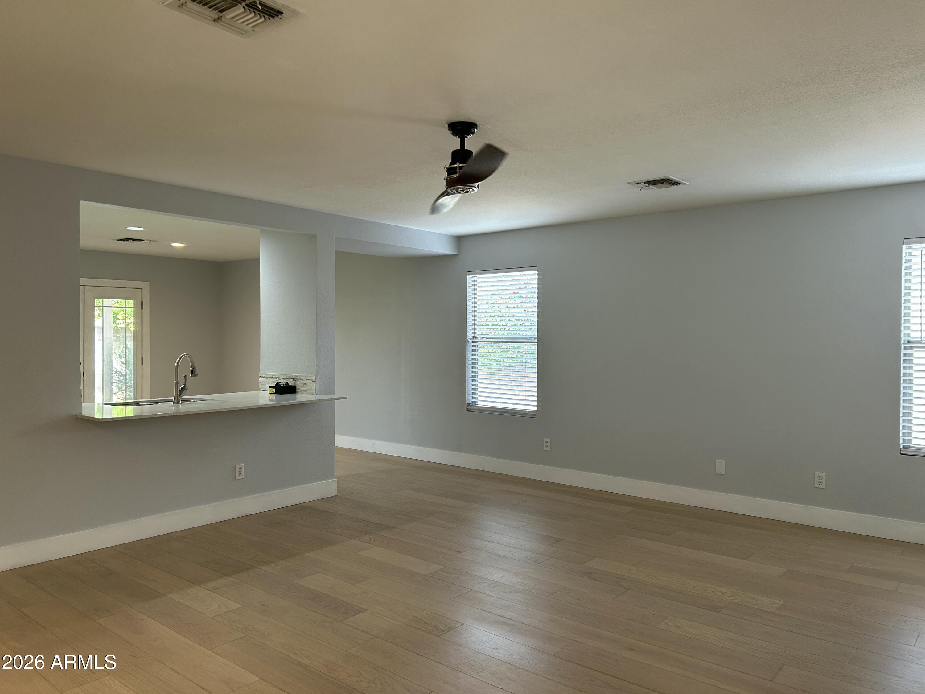 3216 West Mark Lane Phoenix, AZ 85083 - Photo 6 of 23 an empty room with wooden floor and windows