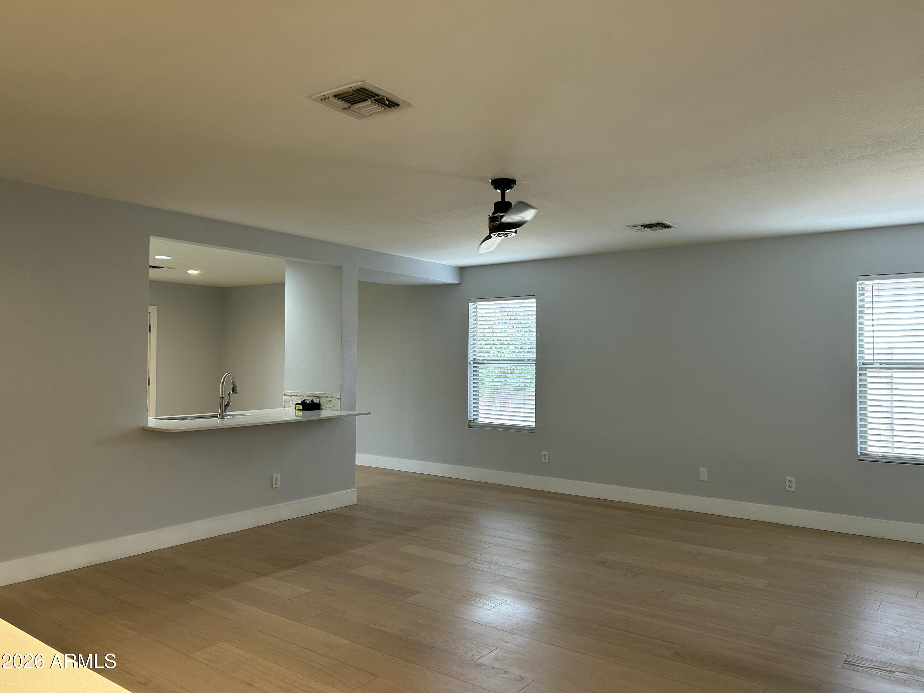 3216 West Mark Lane Phoenix, AZ 85083 - Photo 7 of 23 a view of empty room with wooden floor and fan