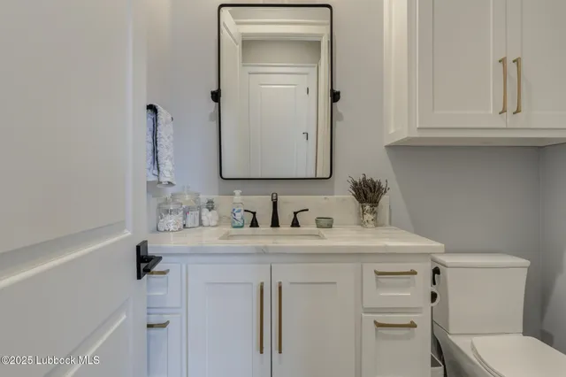 a bathroom with a sink a toilet and mirror