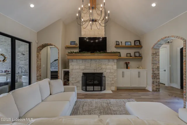 a living room with furniture a fireplace and a chandelier