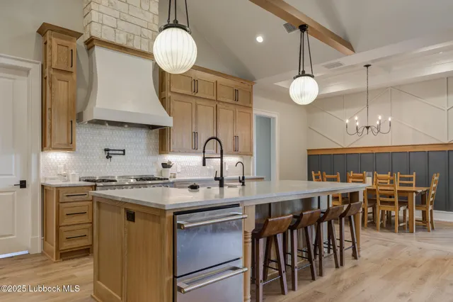 a kitchen with stainless steel appliances a table chairs and a chandelier