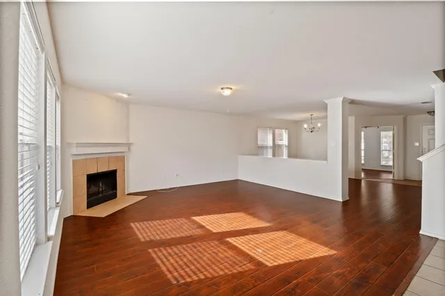 a view of an empty room with window and fire place