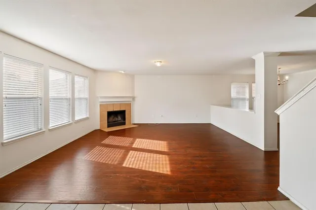 an empty room with wooden floor and fireplace