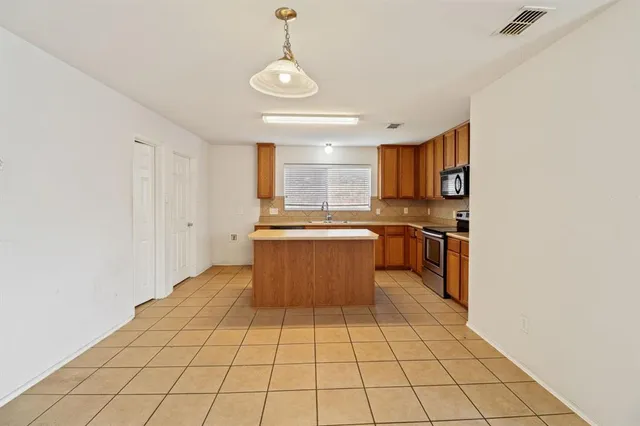 a kitchen with stainless steel appliances a refrigerator and a stove top oven