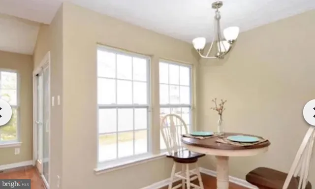 a view of a dining room with furniture and chandelier