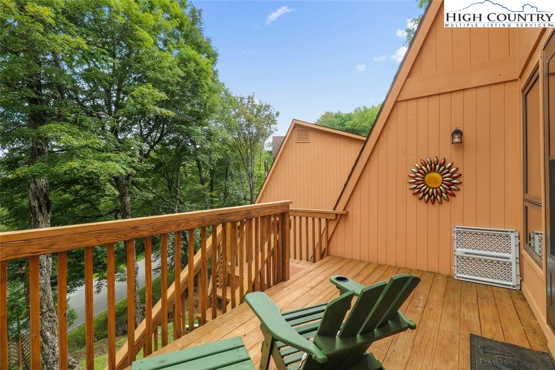 220 Charter Hills Road, Unit B1 Beech Mountain, NC 28604 - Photo 1 of 26 a balcony with wooden floor and outdoor seating