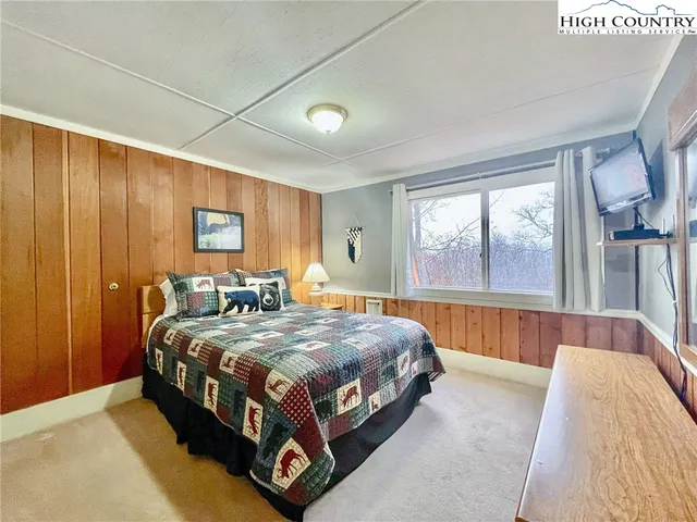 a bed sitting in a spacious bedroom next to a window