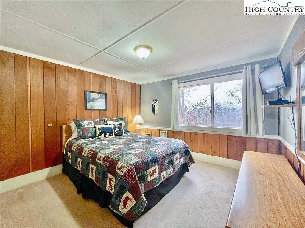 220 Charter Hills Road, Unit B1 Beech Mountain, NC 28604 - Photo 14 of 26 a bed sitting in a spacious bedroom next to a window