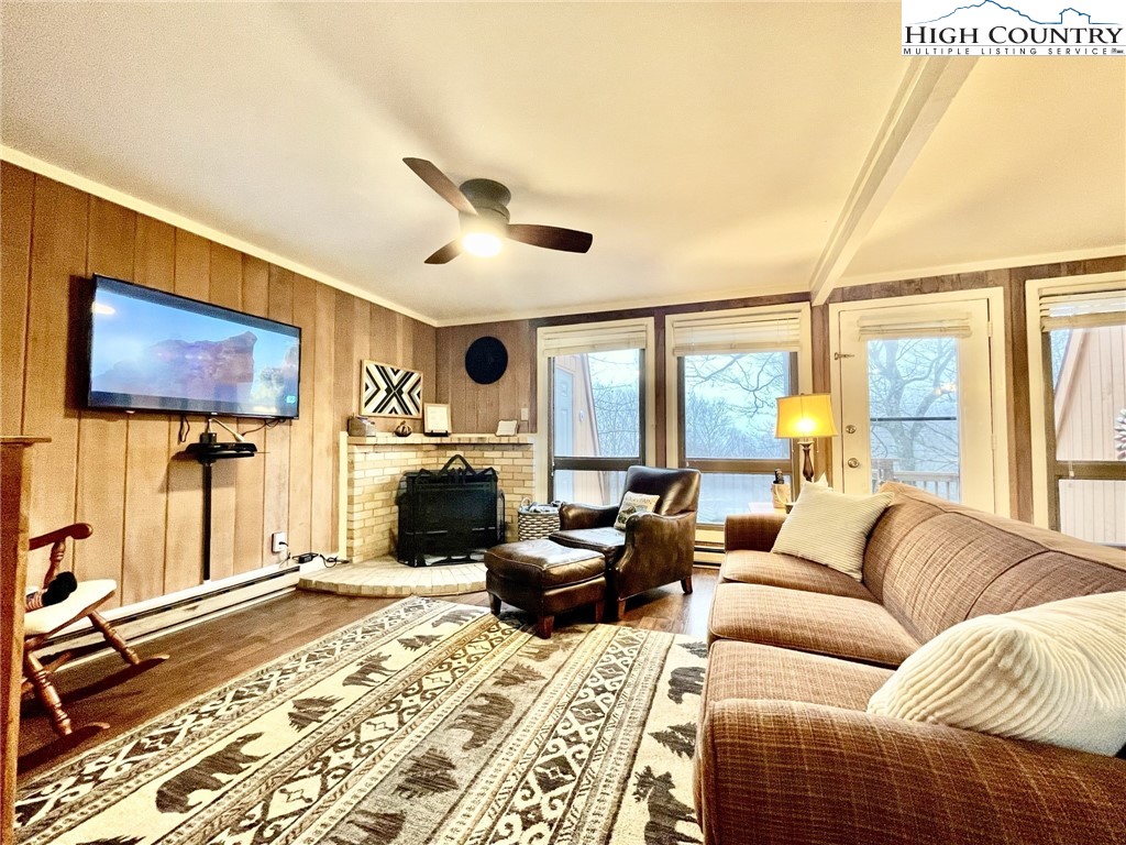 220 Charter Hills Road, Unit B1 Beech Mountain, NC 28604 - Photo 4 of 26 a living room with furniture a flat screen tv and a floor to ceiling window