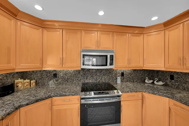 a kitchen with stainless steel appliances granite countertop a stove a sink and a refrigerator