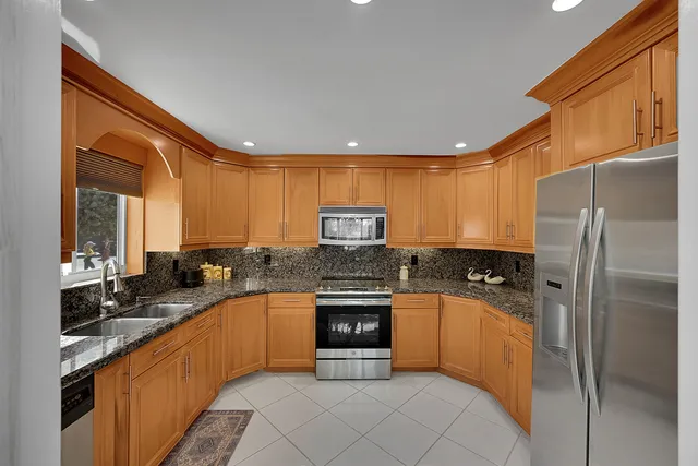 a kitchen with granite countertop a sink stove and cabinets