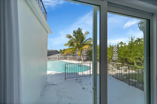 a bedroom with a bed a flat screen tv and bookshelf
