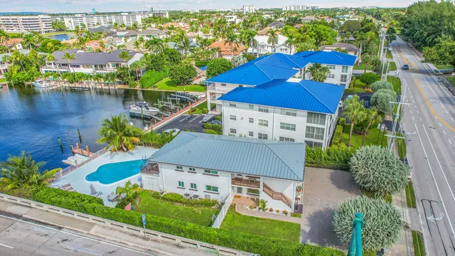 an aerial view of residential houses with outdoor space and a lake view