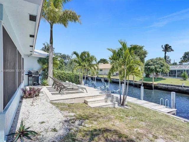 a view of a swimming pool with a patio and plants