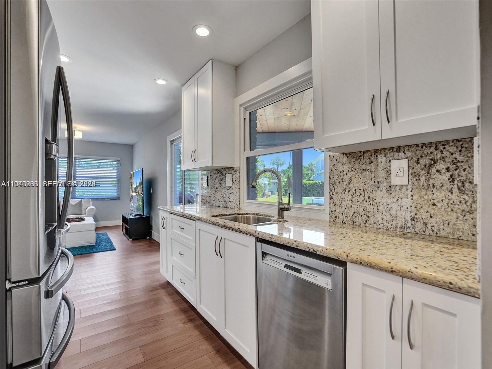 620 West Palmetto Park Road Boca Raton, FL 33486 - Photo 7 of 38 a kitchen with granite countertop a sink a stove cabinets and counter space