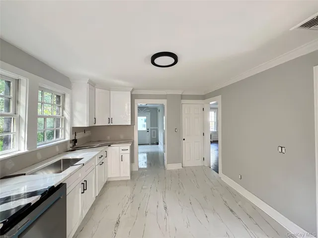 a large kitchen with a lot of cabinets and wooden floor