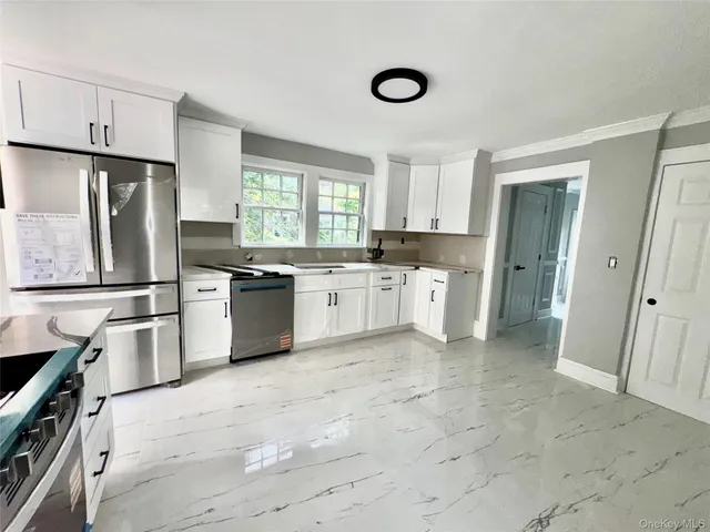 a kitchen with white cabinets and white appliances