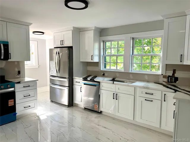 a kitchen with white cabinets and stainless steel appliances
