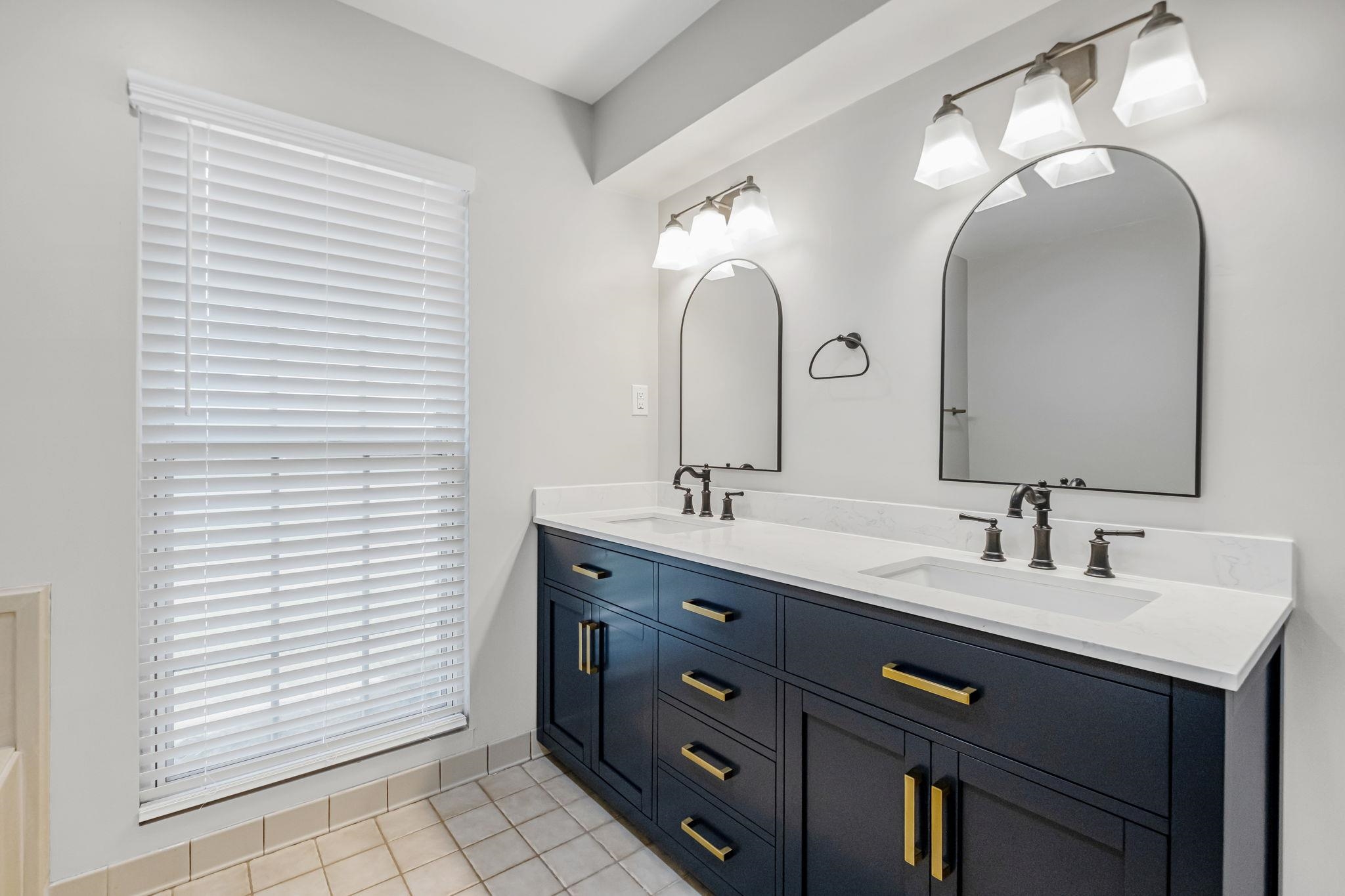 4729 Cedar Ridge Drive Millington, TN 38053 - Photo 21 of 40 Dual vanity with dark blue cabinetry, gold-tone hardware, and white countertops